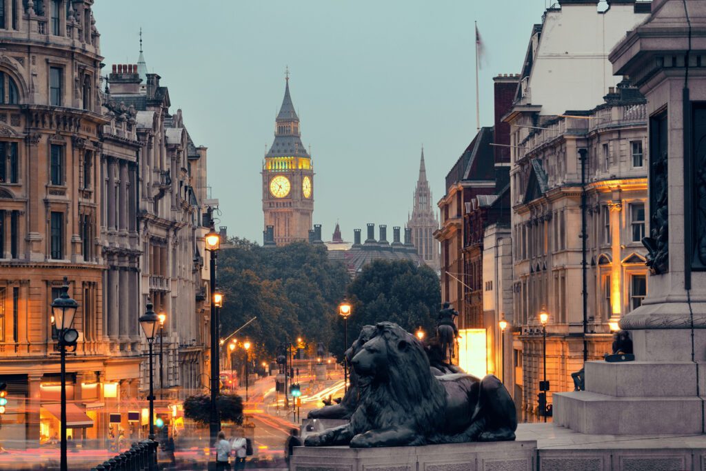 Street view of Trafalgar Square at night in London with Big Ben in the distance